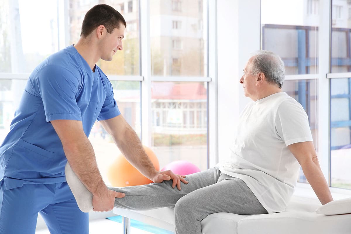 Physiotherapist working with elderly patient in clinic