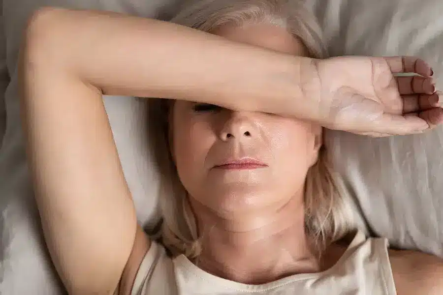 Melancholic woman lying put hand on face feels unwell.jpeg